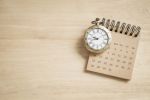Reloj antiguo sobre un calendario de escritorio simbolizando el tiempo necesario para mejorar la microbiota intestinal, revertir la disbiosis y recuperar la sensibilidad a la insulina mediante cambios dietéticos sostenidos.